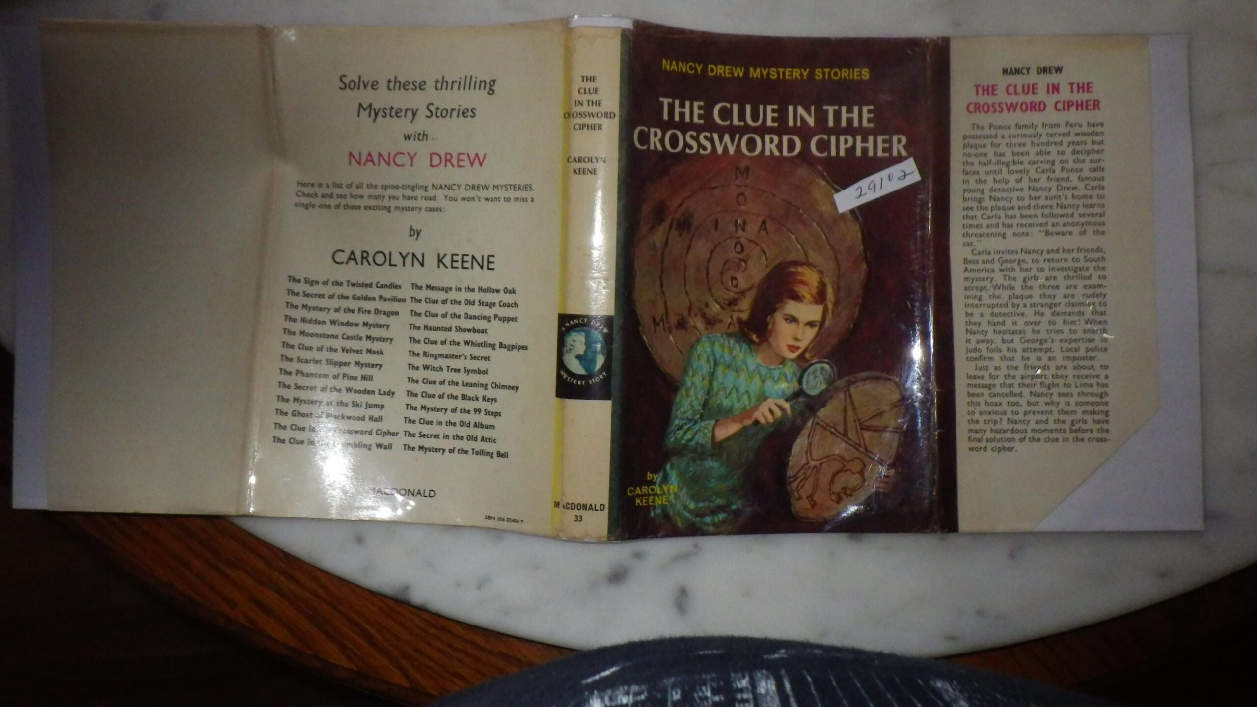 CLUE IN CROSSWORD CIPHER In Color Dustjacket Of Nancy In Green Outfit With Spyglass Looking Ancient Round Wooden Tablet The Nancy Drew Mystery Series 44 33 By The UK Publisher Ponce Family
